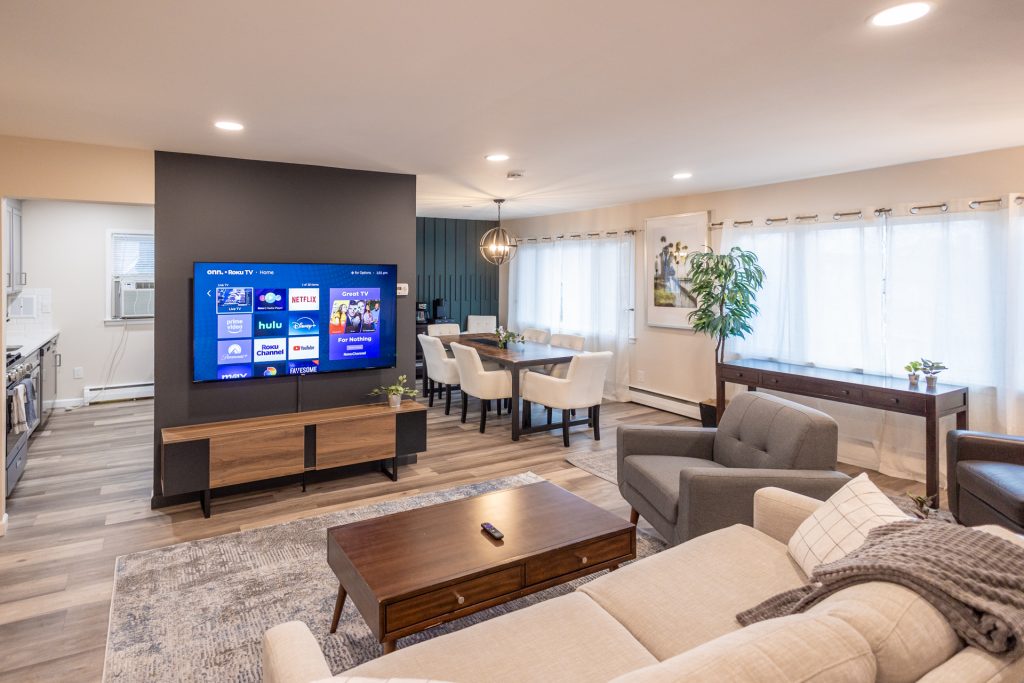 A modern living room showcasing a television mounted on the wall, surrounded by stylish furniture and inviting decor.