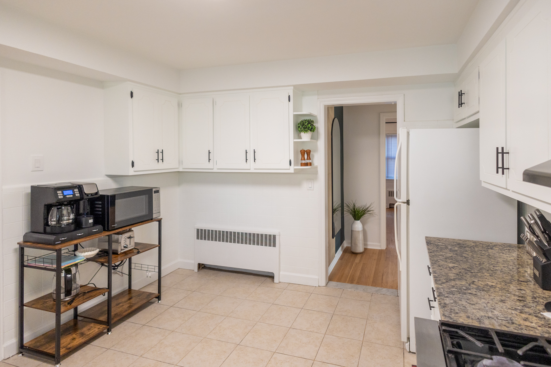 Modern kitchen with white cabinets, granite countertops, and stainless steel appliances, combining style and functionality.
