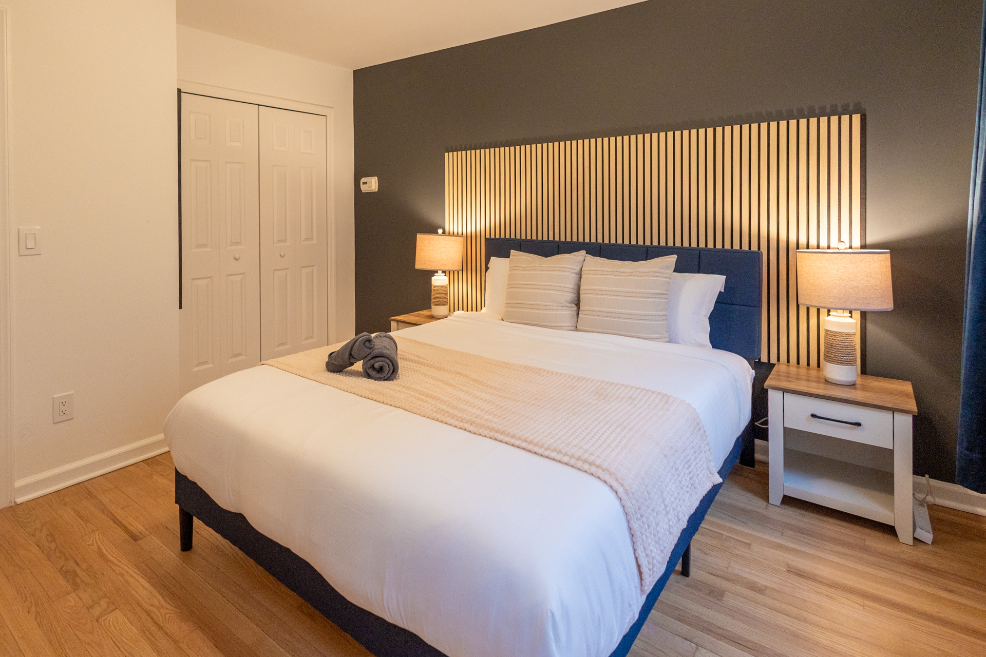 Light-filled bedroom with white bedding and natural wood accents.