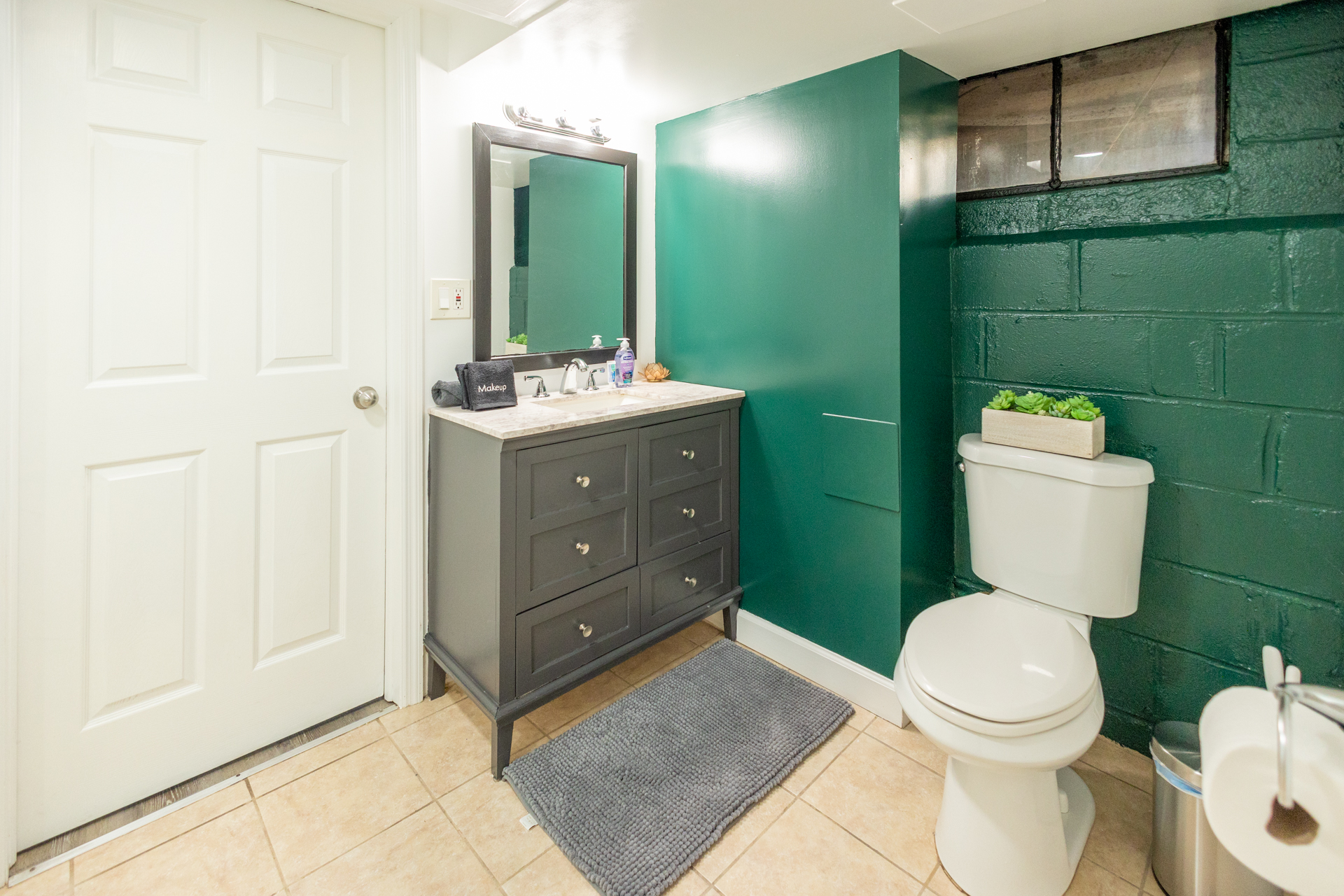 Functional full bathroom with a toilet, sink, and mirror-equipped cabinet for organized living.