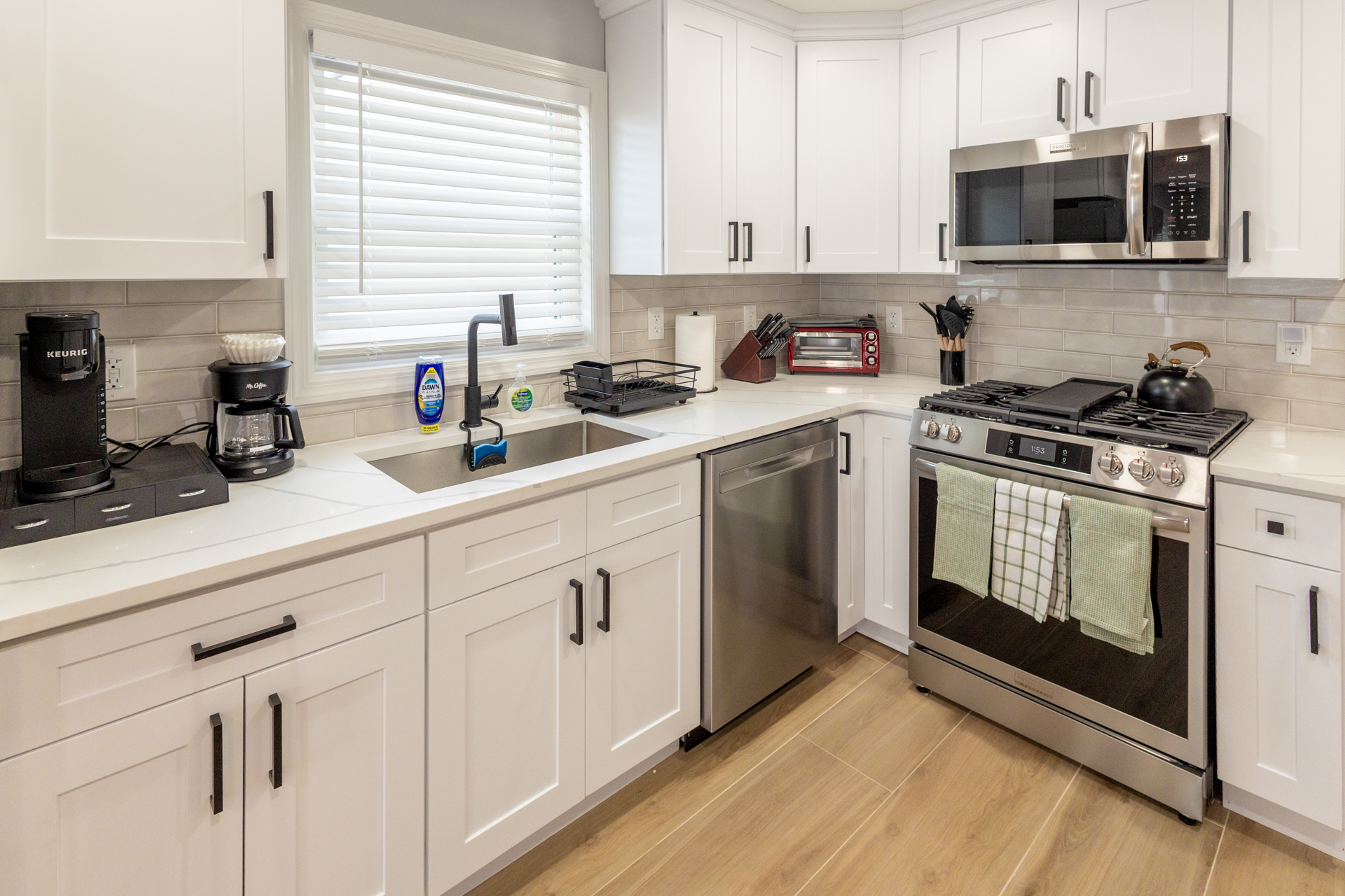 Bright kitchen with white cabinetry, stainless steel appliances, and ample counter space.