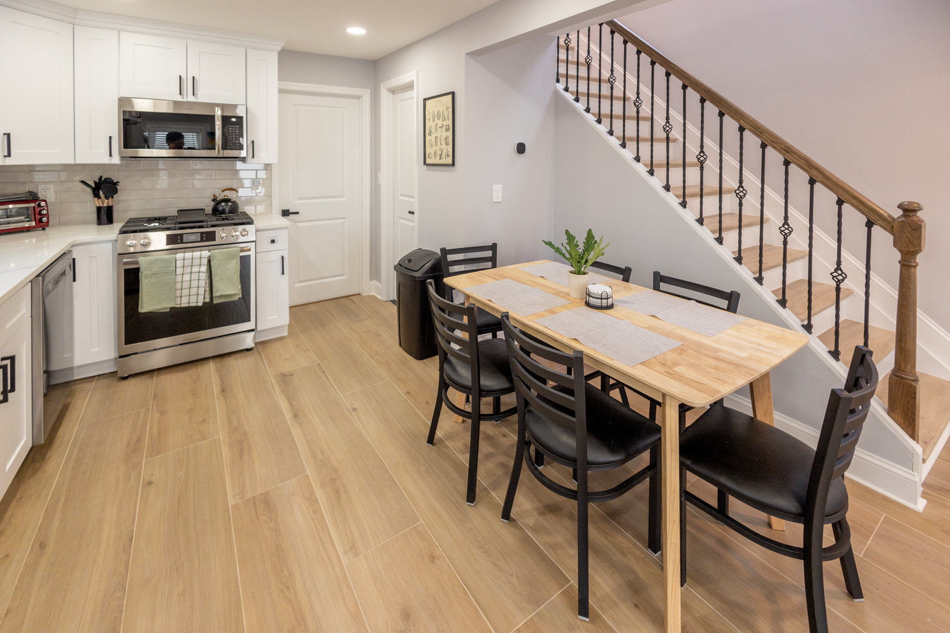 Bright dining area with a large table, seating for six, and an adjacent fully equipped kitchen.